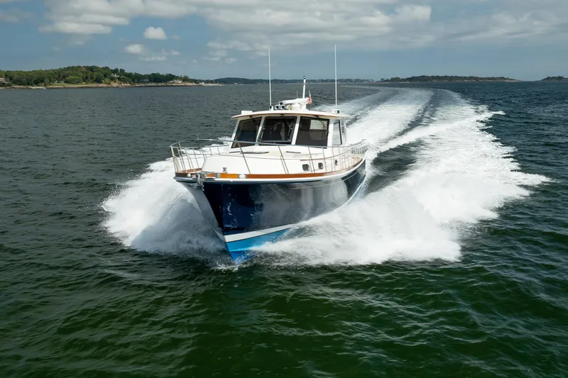 Whole Life Yacht Photos Pics 2011 Grand Banks 46 Eastbay SX cruising on open water, creating a dynamic wake.
