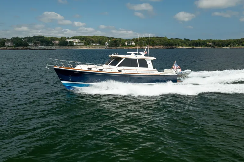 Whole Life Yacht Photos Pics 2011 Grand Banks 46 Eastbay SX cruising on open water, scenic shoreline in background.