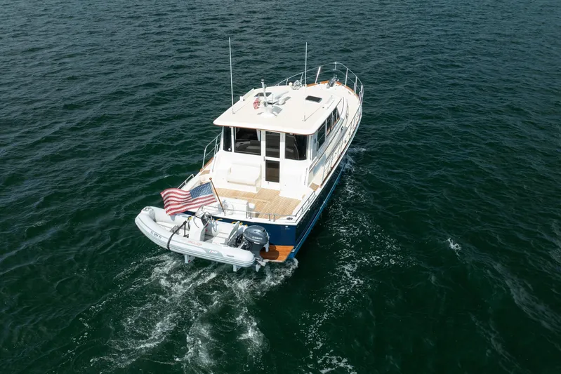 Whole Life Yacht Photos Pics 2011 Grand Banks 46 Eastbay SX yacht cruising on open water with American flag.