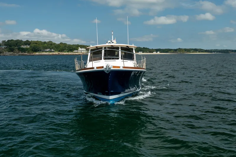 Whole Life Yacht Photos Pics 2011 Grand Banks 46 Eastbay SX cruising on open water under a partly cloudy sky.