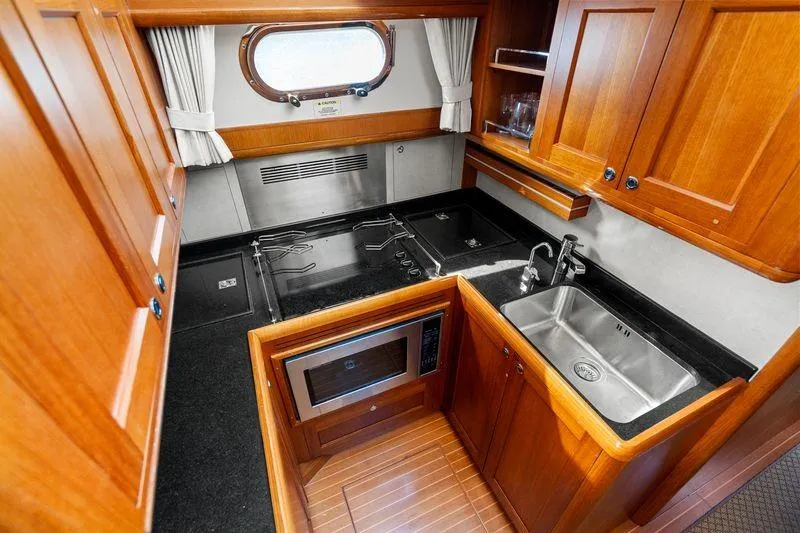 Whole Life Yacht Photos Pics Luxurious 2011 Grand Banks 46 Eastbay SX yacht kitchen with wood cabinetry and modern appliances.