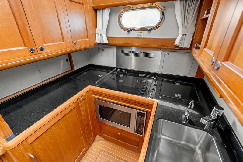 Whole Life Yacht Photos Pics Luxurious 2011 Grand Banks 46 Eastbay SX yacht kitchen with wood cabinetry and modern appliances.