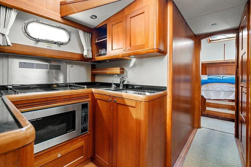 Whole Life Yacht Photos Pics Luxurious 2011 Grand Banks 46 Eastbay SX yacht interior with modern kitchen and cozy bedroom.