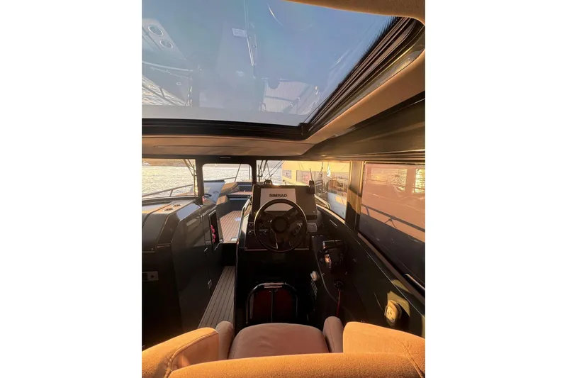  Yacht Photos Pics Interior view of 2021 XO EXPLORER 10S boat cockpit with steering wheel and navigation equipment.