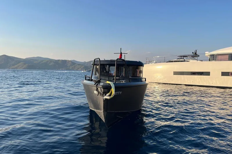  Yacht Photos Pics 2021 XO EXPLORER 10S boat on calm water with scenic mountain backdrop.