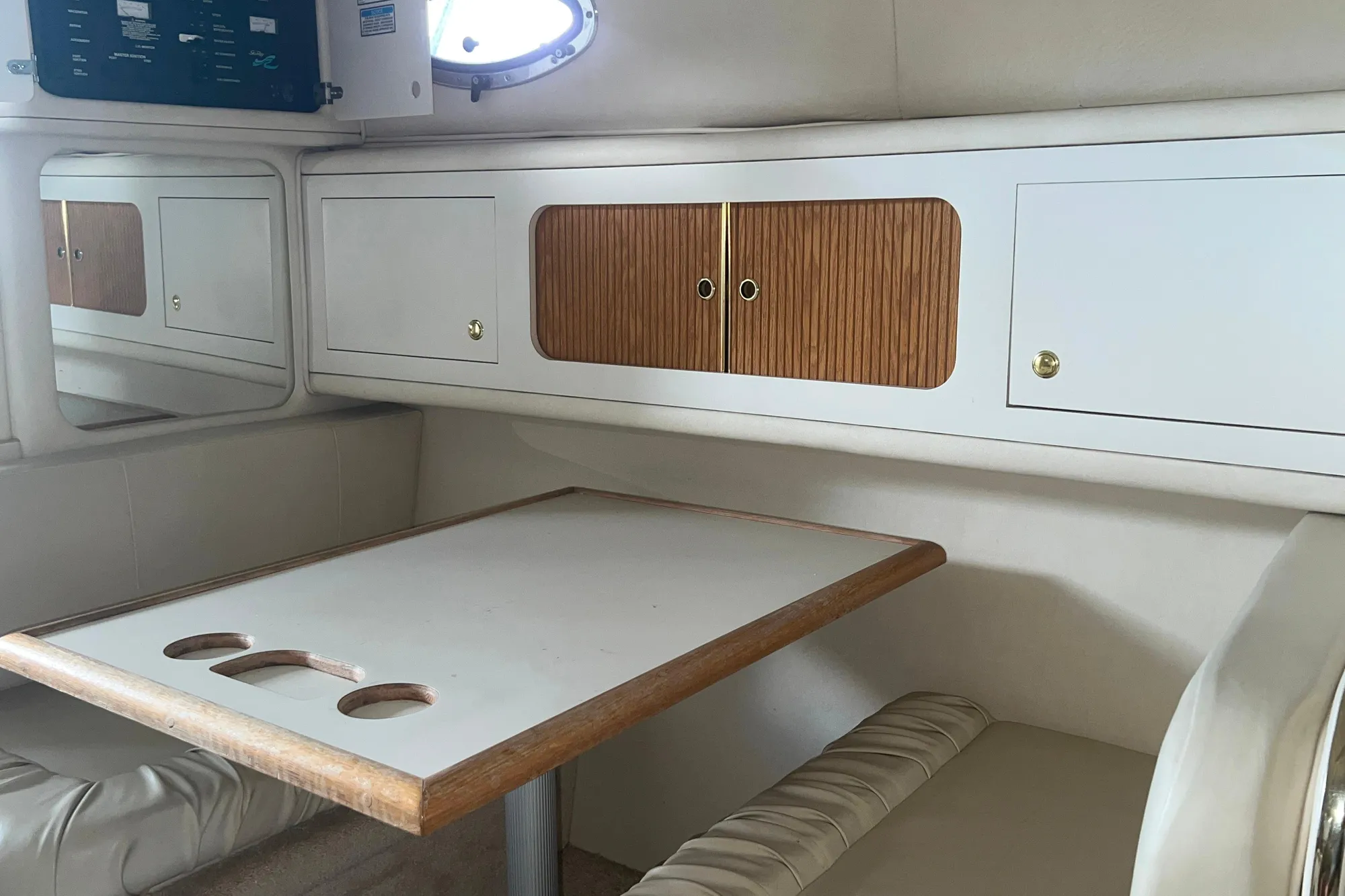 1999 Sea Ray 290 Sundancer cabin interior with table and storage cabinets.
