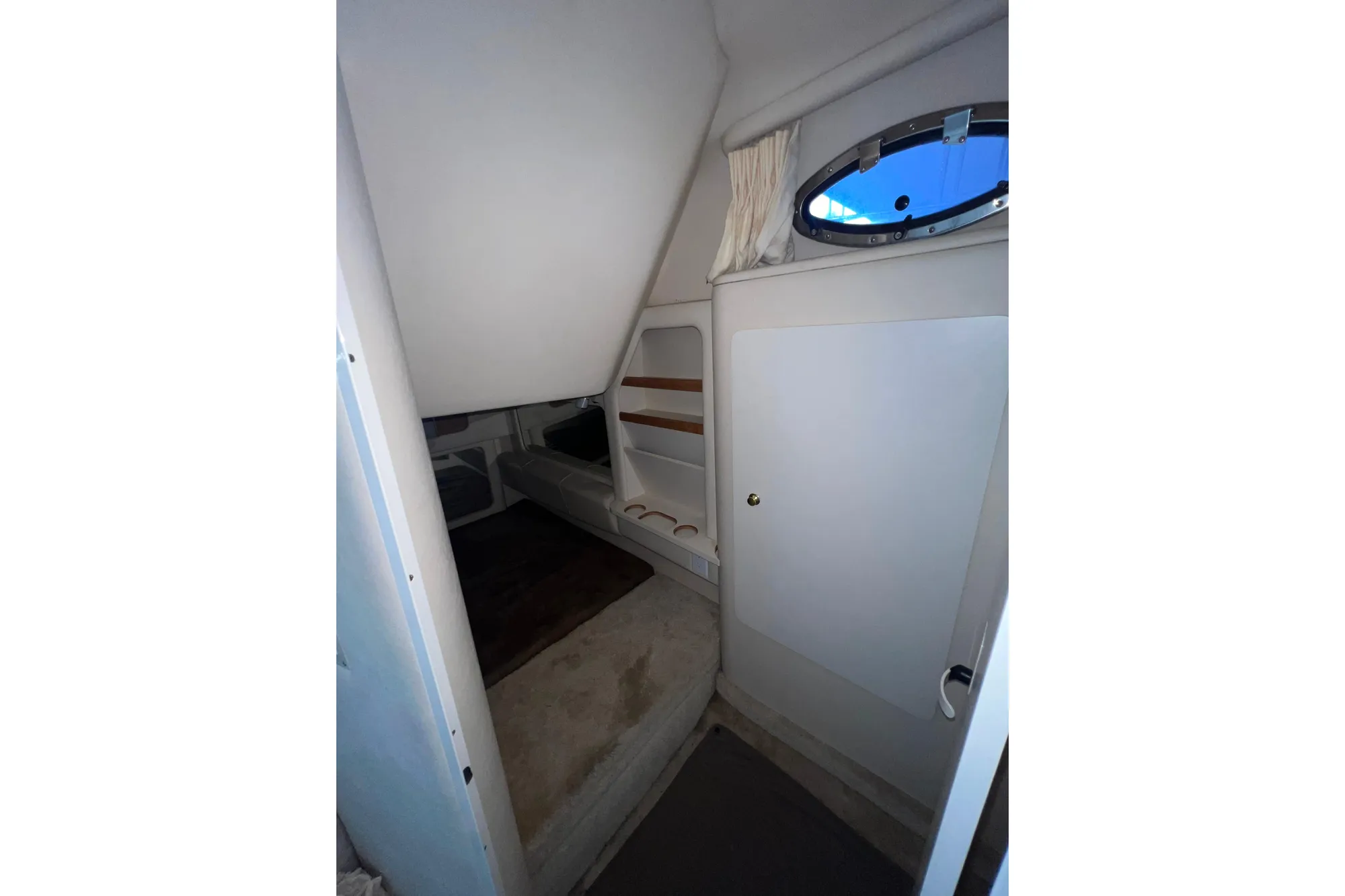 Interior cabin of 1999 Sea Ray 290 Sundancer with window and seating area.