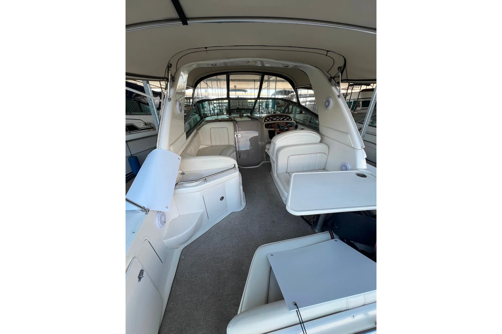 1999 Sea Ray 290 Sundancer interior with seating and helm, showcasing spacious design.