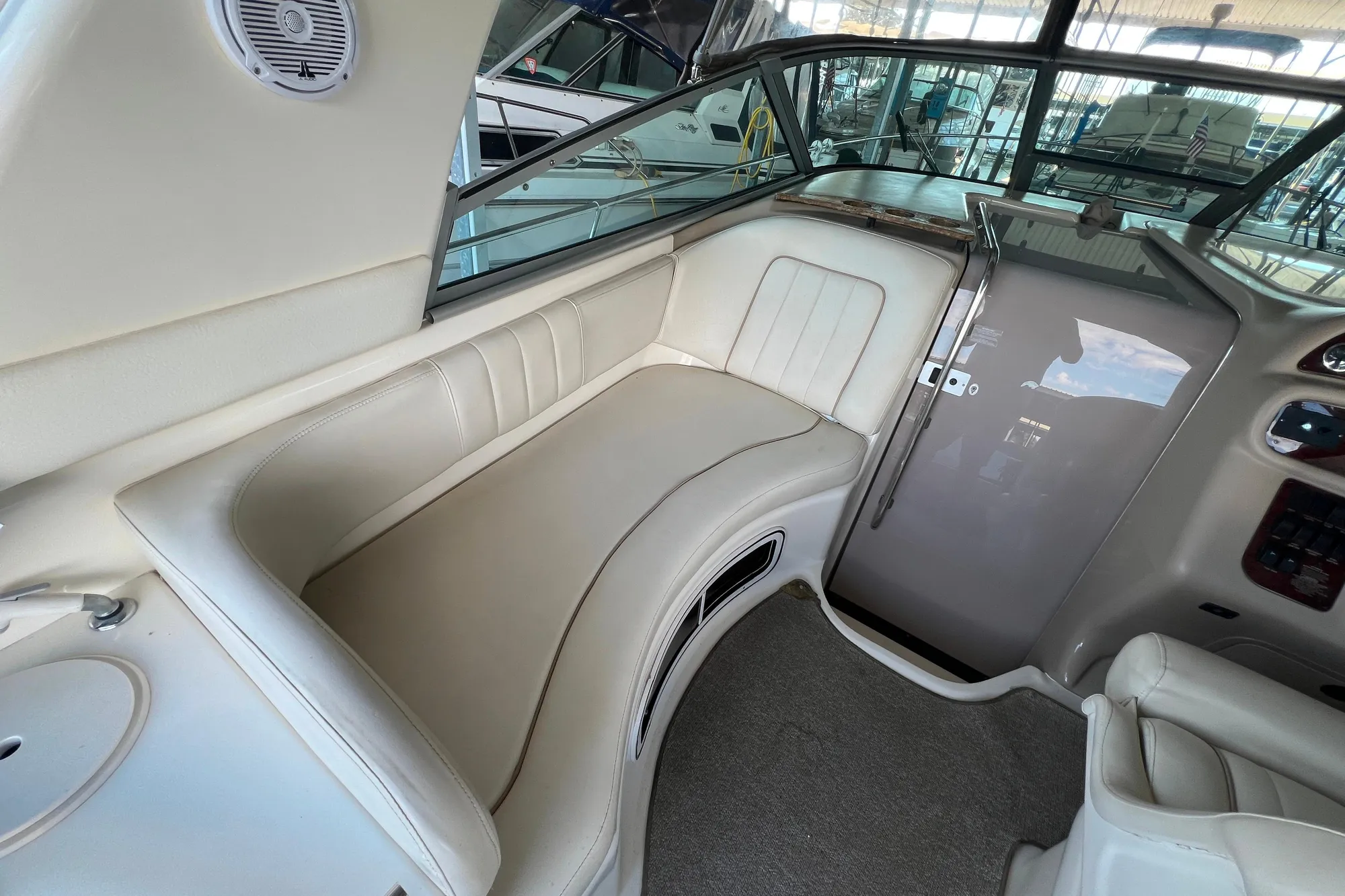 1999 Sea Ray 290 Sundancer interior with beige seating and helm area.