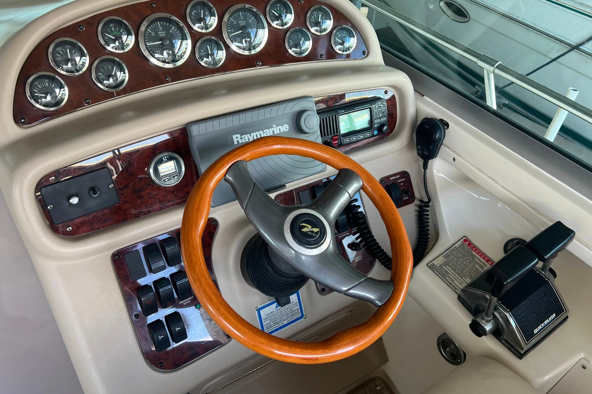 1999 Sea Ray 290 Sundancer helm with wood steering wheel and navigation instruments.