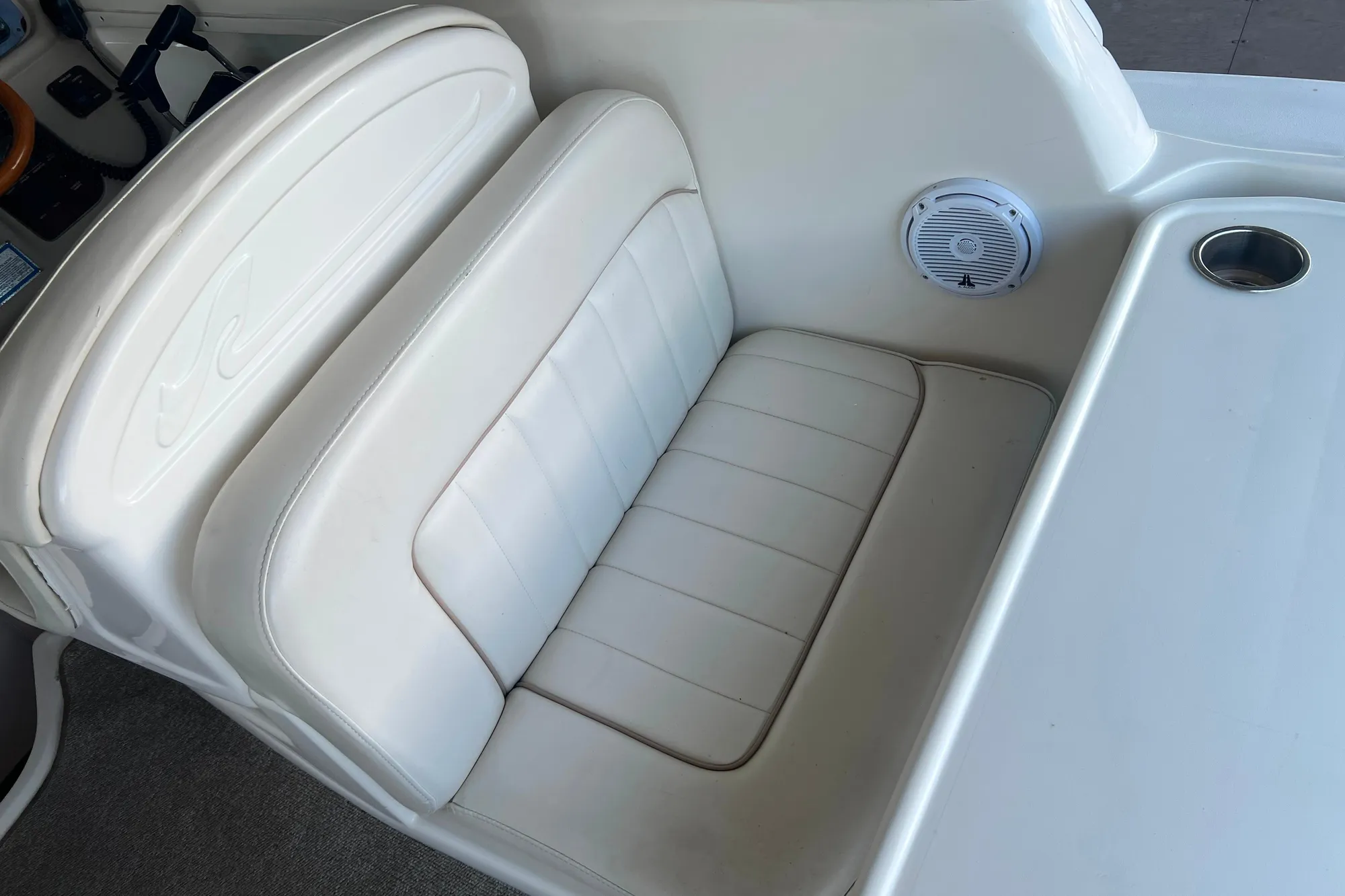 White leather seating on 1999 Sea Ray 290 Sundancer boat, featuring speaker and cup holder.