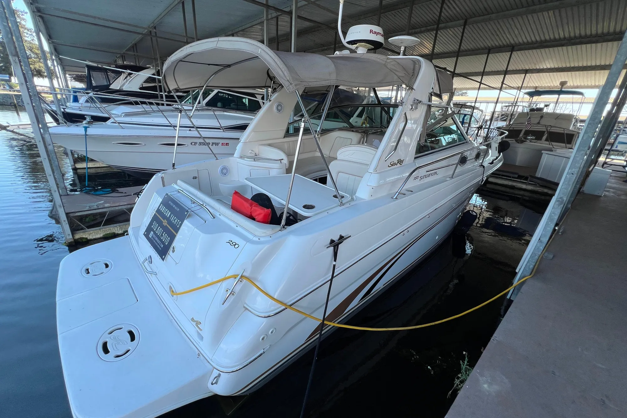 1999 Sea Ray 290 Sundancer docked in a covered marina.