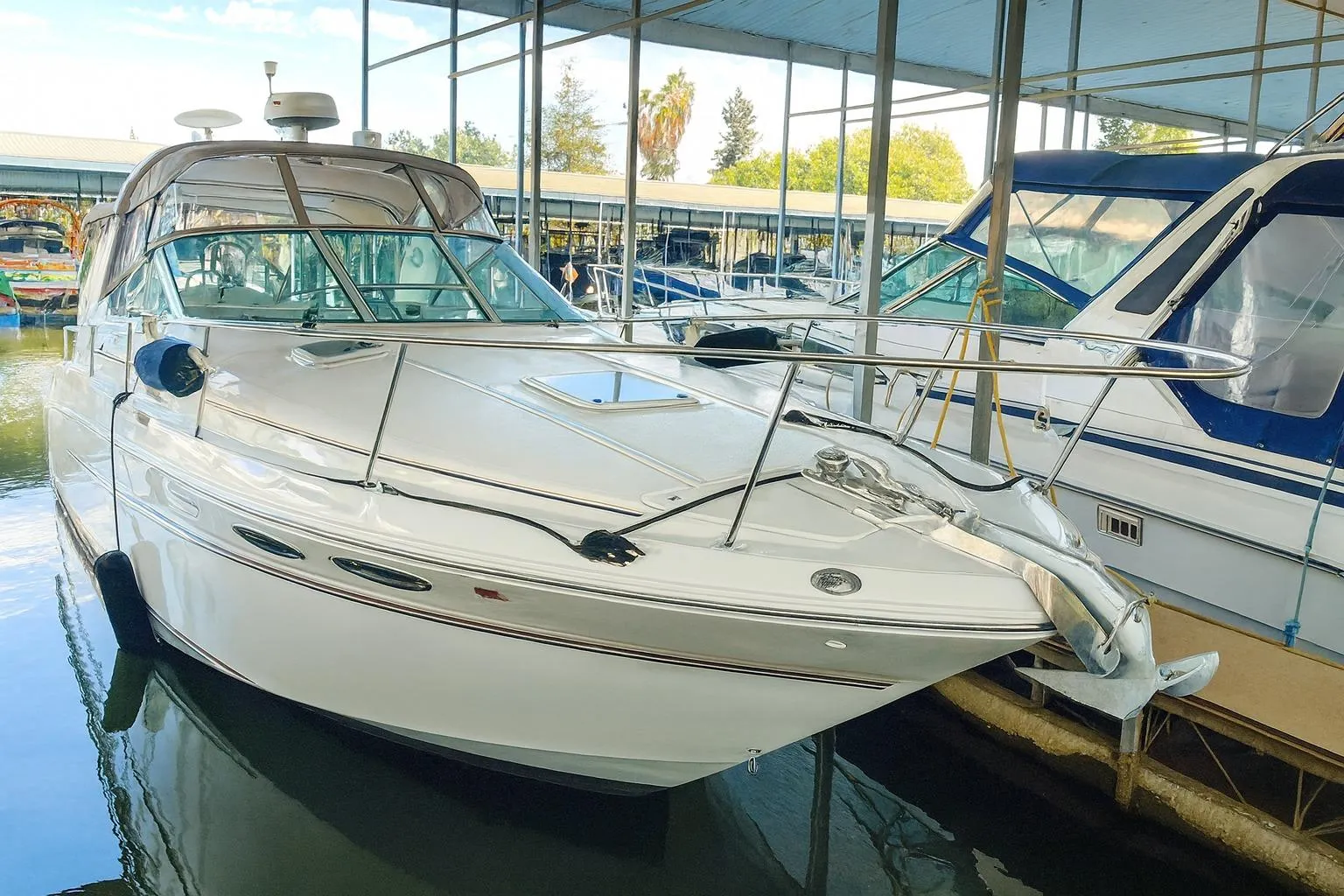1999 Sea Ray 290 Sundancer docked in a marina, showcasing sleek design and modern features.