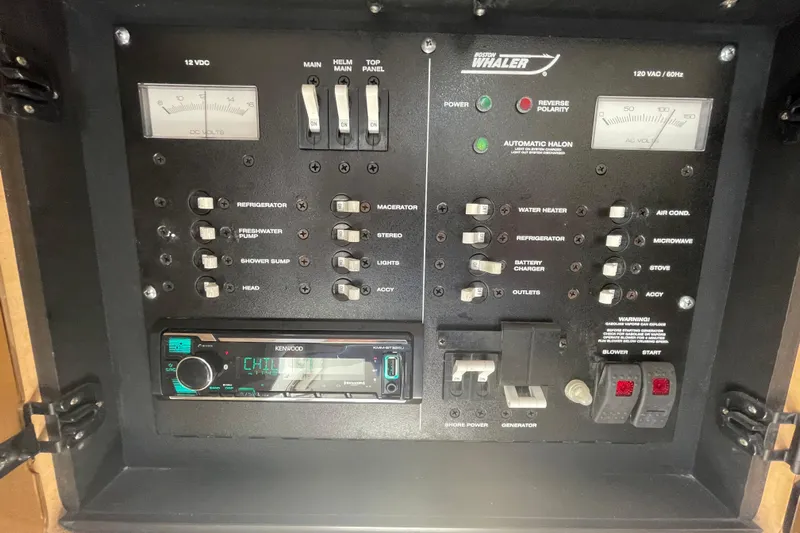 Mad Fish Yacht Photos Pics Electrical control panel of a 2001 Boston Whaler 28 Conquest boat with various switches and gauges.