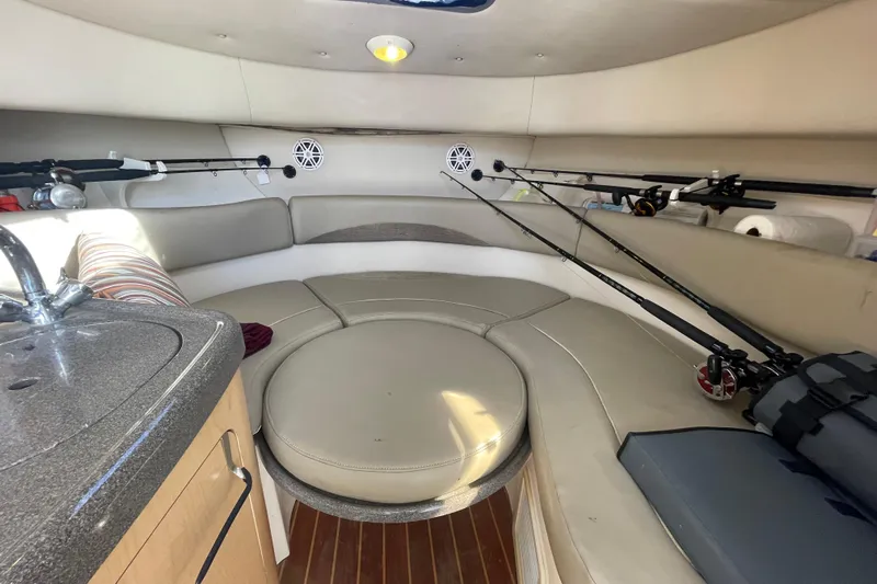 Mad Fish Yacht Photos Pics Interior of 2001 Boston Whaler 28 Conquest boat with fishing rods and seating area.