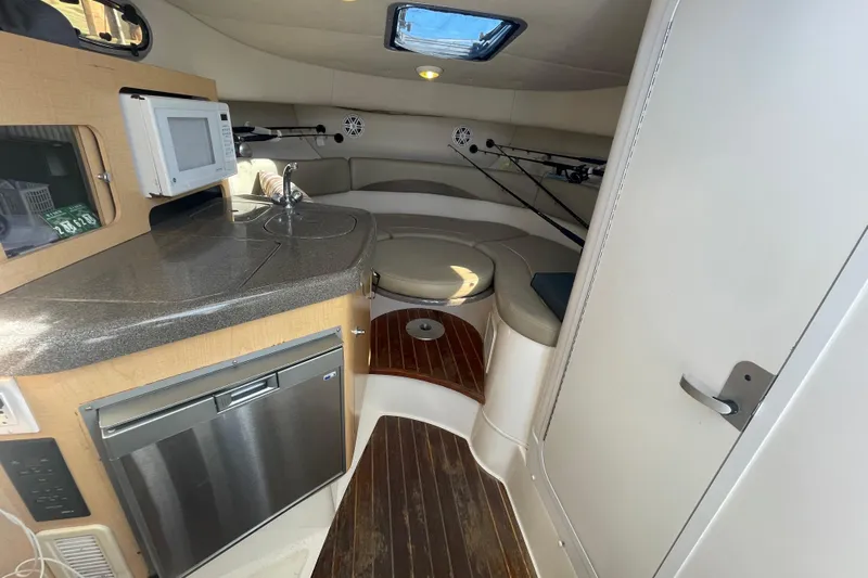 Mad Fish Yacht Photos Pics Interior of 2001 Boston Whaler 28 Conquest boat with kitchenette and seating area.