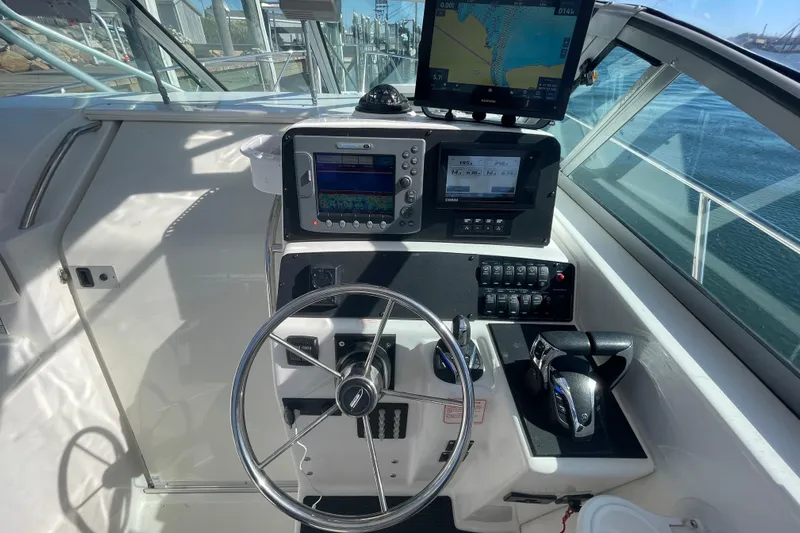 Mad Fish Yacht Photos Pics 2001 Boston Whaler 28 Conquest helm with navigation equipment and steering wheel.