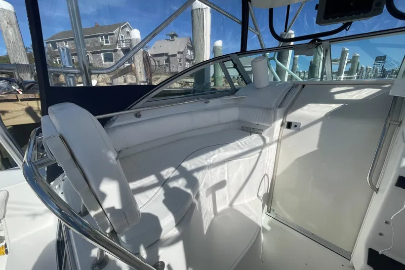 Mad Fish Yacht Photos Pics 2001 Boston Whaler 28 Conquest boat interior with white seating and marina view.
