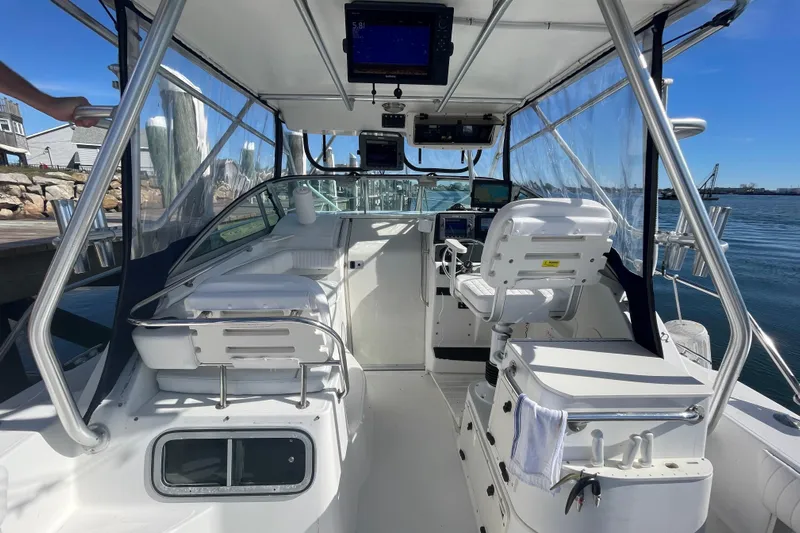Mad Fish Yacht Photos Pics Interior view of a 2001 Boston Whaler 28 Conquest boat, featuring helm and seating.