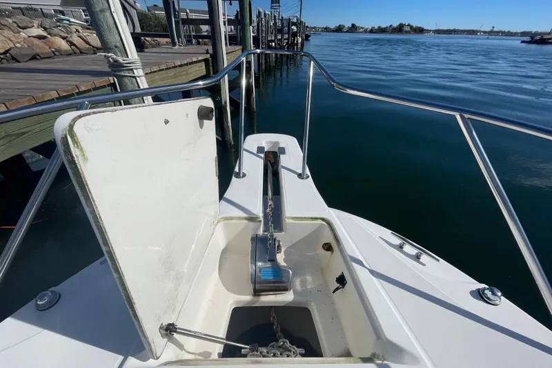 Mad Fish Yacht Photos Pics 2001 Boston Whaler 28 Conquest anchor compartment, docked by calm waters.