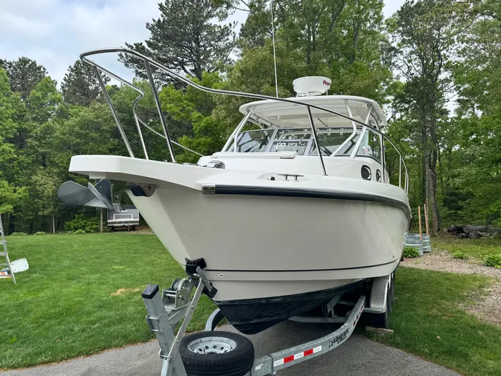 Yacht Photos Pics 2011 Boston Whaler 305 Conquest boat on trailer, surrounded by lush greenery.