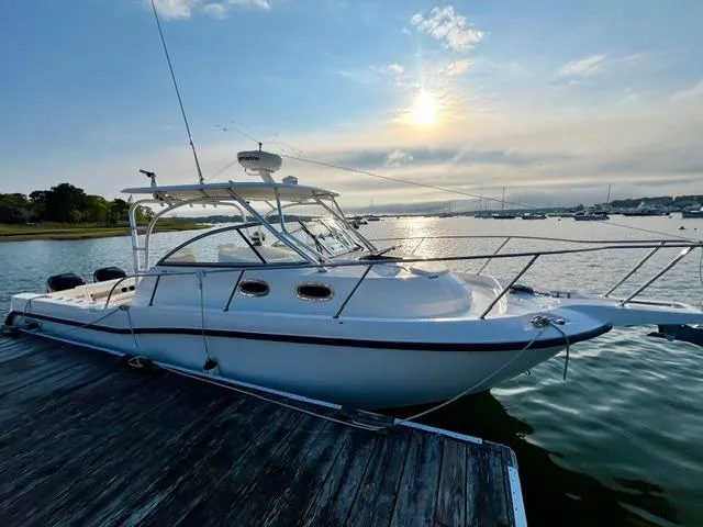  Yacht Photos Pics 2011 Boston Whaler 305 Conquest docked at sunset, calm waters, scenic view.