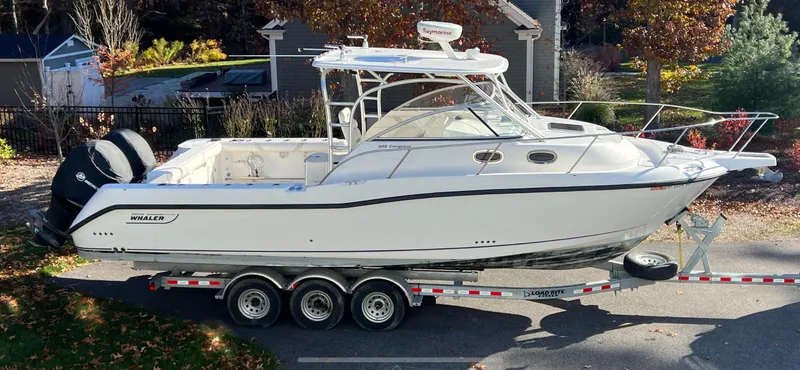  Yacht Photos Pics 2011 Boston Whaler 305 Conquest boat on trailer, parked outdoors in a residential area.