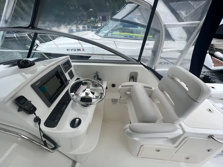  Yacht Photos Pics 2011 Boston Whaler 305 Conquest helm with steering wheel and navigation equipment.