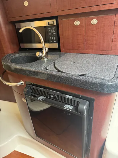  Yacht Photos Pics 2011 Boston Whaler 305 Conquest kitchen with sink, microwave, and fridge.