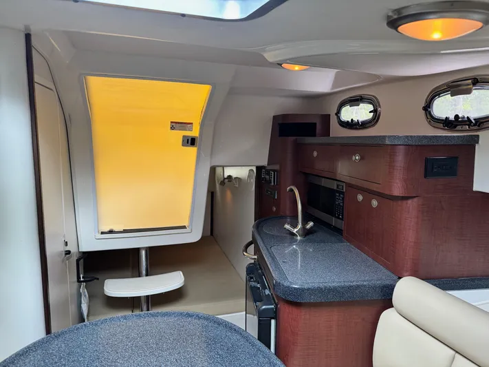  Yacht Photos Pics 2011 Boston Whaler 305 Conquest cabin interior with kitchenette and seating area.