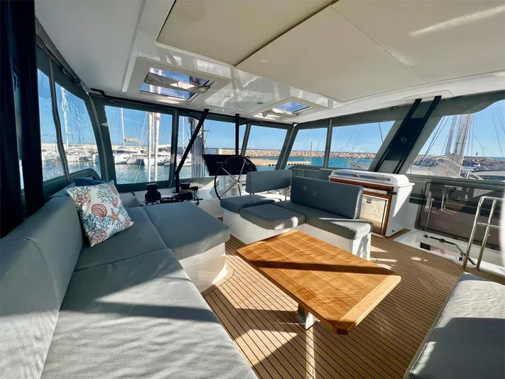 Tbd Yacht Photos Pics Luxurious interior of 2022 Fountaine Pajot Samana 59 yacht with spacious seating and wooden table.