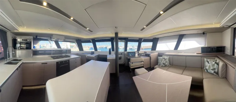 Tbd Yacht Photos Pics Luxurious interior of 2022 Fountaine Pajot Samana 59 yacht with modern kitchen and seating area.