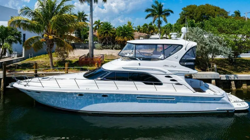 Southern Seas Yacht Photos Pics 1999 Sea Ray 56 Sedan Bridge yacht docked by palm trees and waterfront homes.