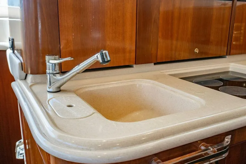 Southern Seas Yacht Photos Pics 1999 Sea Ray 56 Sedan Bridge kitchen sink with wooden cabinetry and modern faucet.