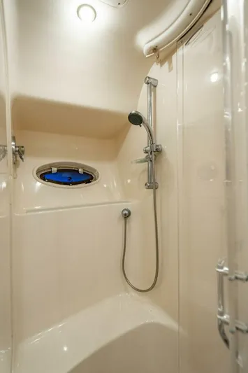 Southern Seas Yacht Photos Pics Shower area in 1999 Sea Ray 56 Sedan Bridge yacht, featuring modern fixtures and porthole window.