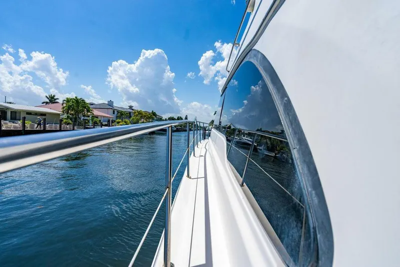 Southern Seas Yacht Photos Pics 1999 Sea Ray 56 Sedan Bridge yacht cruising on a sunny day, reflecting blue skies and clouds.