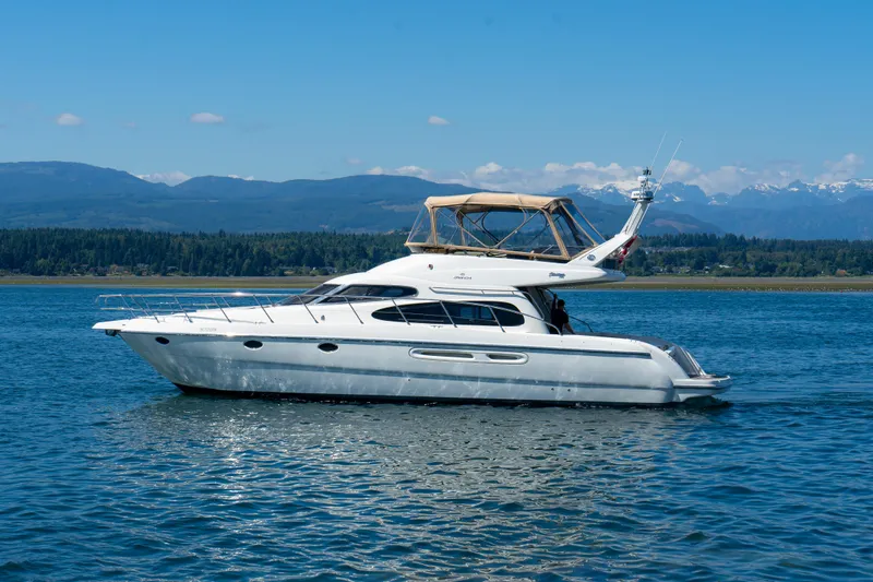 Italian Job Yacht Photos Pics 2001 Cranchi Atlantique yacht cruising on a scenic lake with mountains in the background.