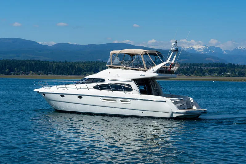 Italian Job Yacht Photos Pics 2001 Cranchi Atlantique yacht cruising on a scenic lake with mountains in the background.