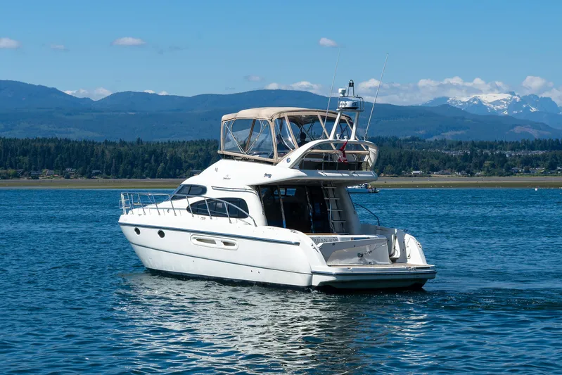 Italian Job Yacht Photos Pics 2001 Cranchi Atlantique yacht cruising on a scenic lake with mountain backdrop.