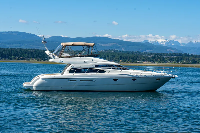 Italian Job Yacht Photos Pics 2001 Cranchi Atlantique yacht cruising on a scenic lake with mountains in the background.