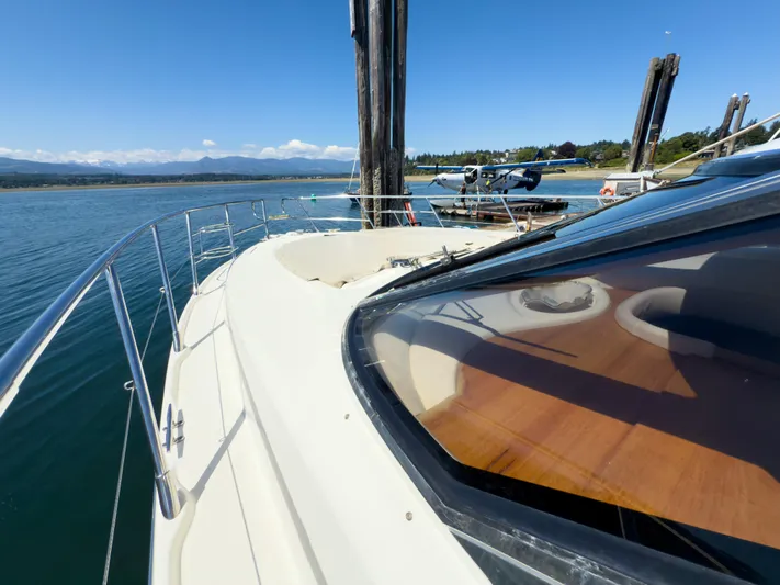 Italian Job Yacht Photos Pics 2001 Cranchi Atlantique yacht docked by a seaplane, scenic coastal view.