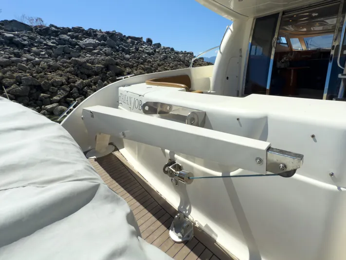 Italian Job Yacht Photos Pics 2001 Cranchi Atlantique yacht deck with davit system, rocky shoreline in background.