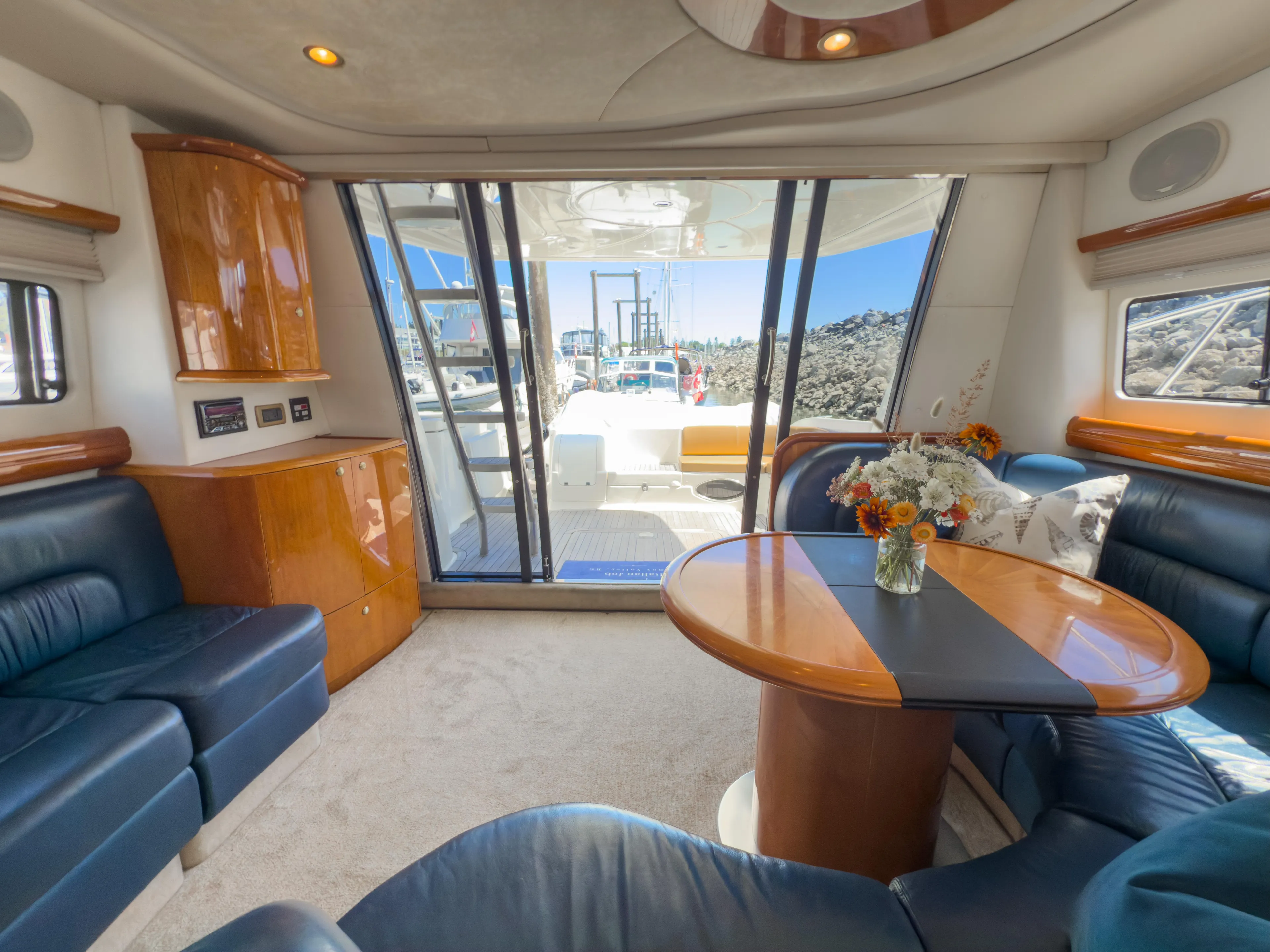 Italian Job Yacht Photos Pics Luxurious interior of 2001 Cranchi Atlantique yacht with elegant seating and floral centerpiece.