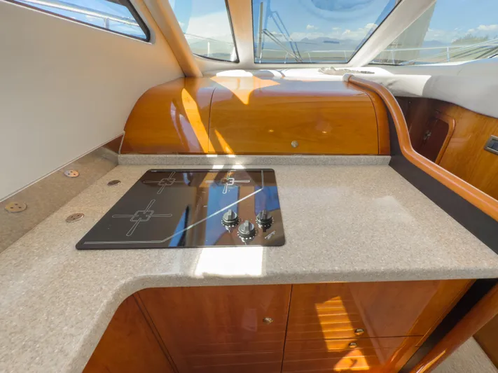 Italian Job Yacht Photos Pics 2001 Cranchi Atlantique yacht kitchen with sleek countertop and modern stovetop.