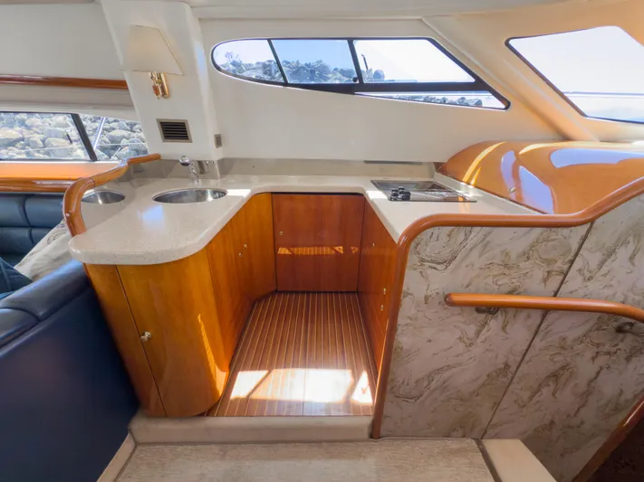 Italian Job Yacht Photos Pics 2001 Cranchi Atlantique yacht interior with wooden cabinetry and modern kitchen amenities.