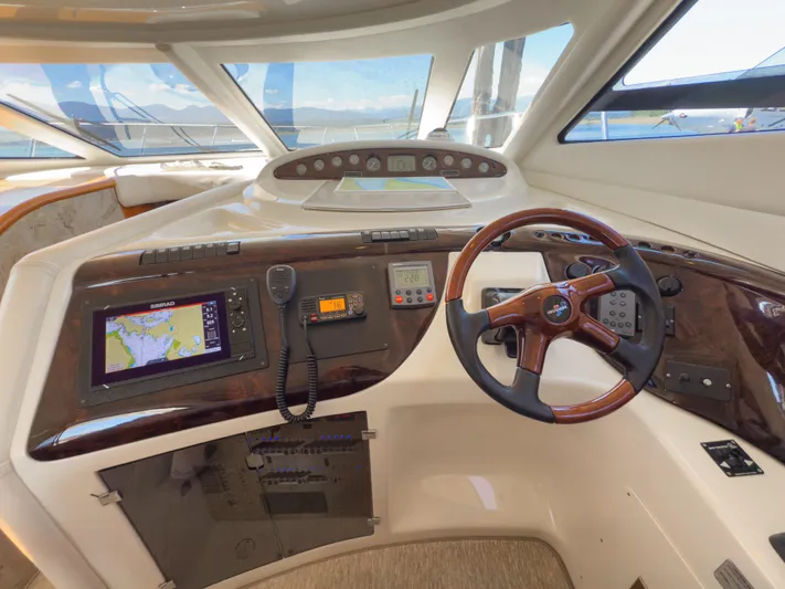 Italian Job Yacht Photos Pics 2001 Cranchi Atlantique yacht helm with navigation equipment and wooden steering wheel.