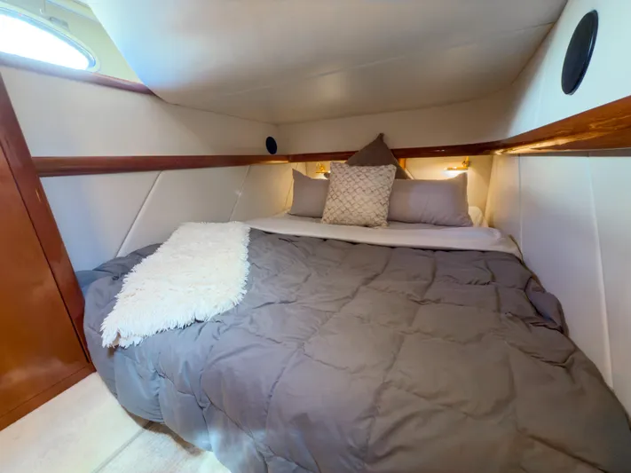 Italian Job Yacht Photos Pics Cozy cabin bedroom in 2001 Cranchi Atlantique yacht with plush bedding and ambient lighting.