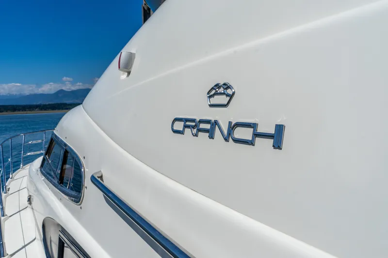 Italian Job Yacht Photos Pics 2001 Cranchi Atlantique yacht on water, showcasing sleek design and logo.