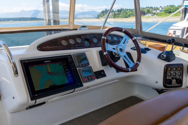 Italian Job Yacht Photos Pics 2001 Cranchi Atlantique yacht helm with navigation equipment and scenic water view.