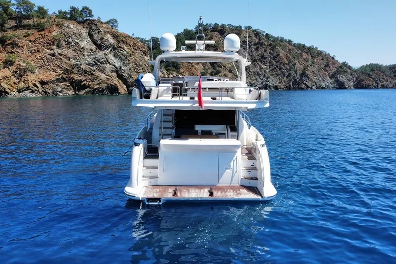  Yacht Photos Pics Azimut 70 yacht from 2010 on clear blue water near rocky coastline.